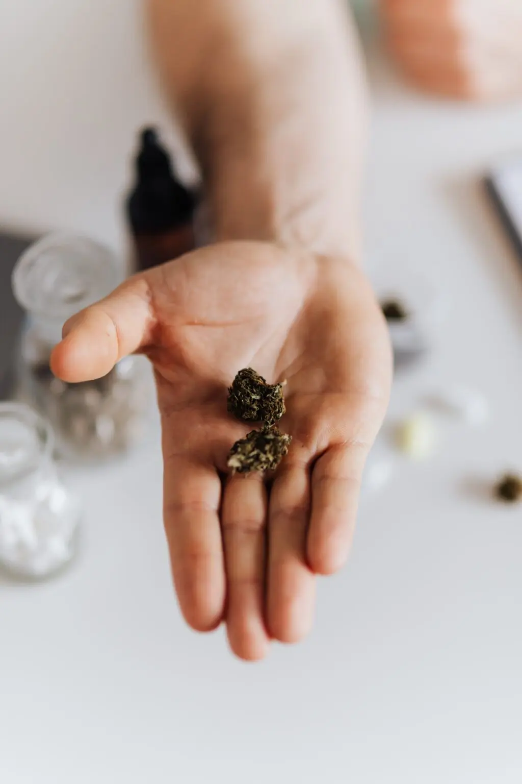 Bild einer Hand mit Cannabis mit daneben stehendem Inhalt über die Einlösung eines Cannabisrezepts